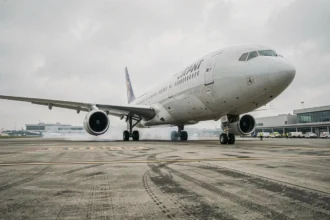 Avion de ligne commercial sur le tarmac d'un aéroport, illustrant les émissions polluantes du transport aérien
