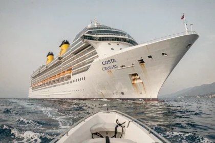 Paquebot Costa Cruises naviguant en mer Méditerranée avec sa coque blanche et ses cheminées jaunes emblématiques